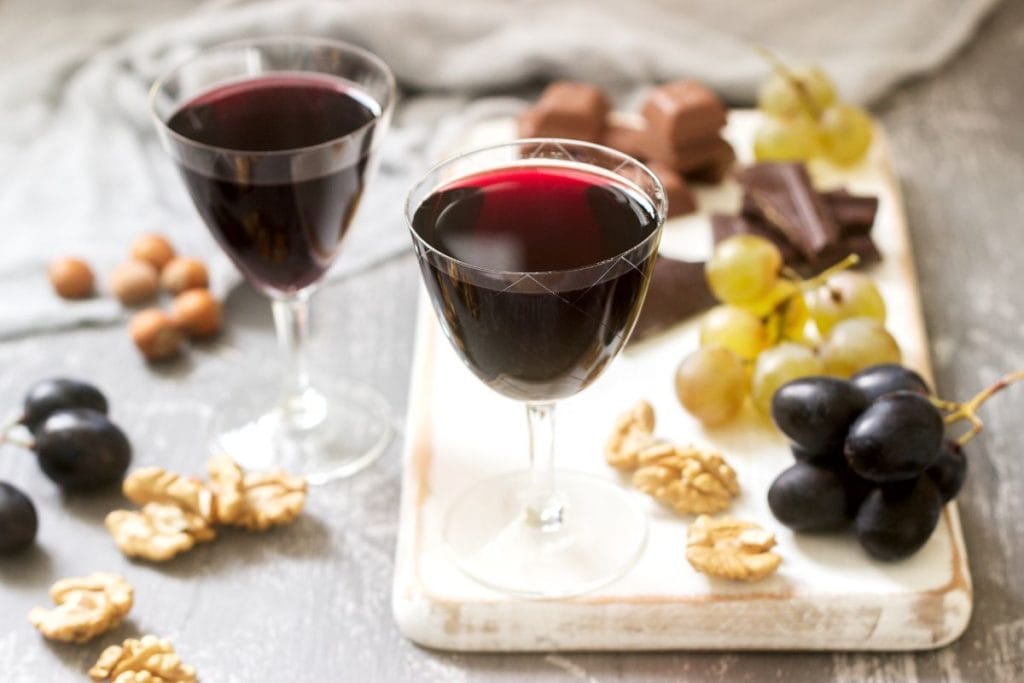 Creme de Cassis homemade liqueur served with grapes, nuts and chocolate.