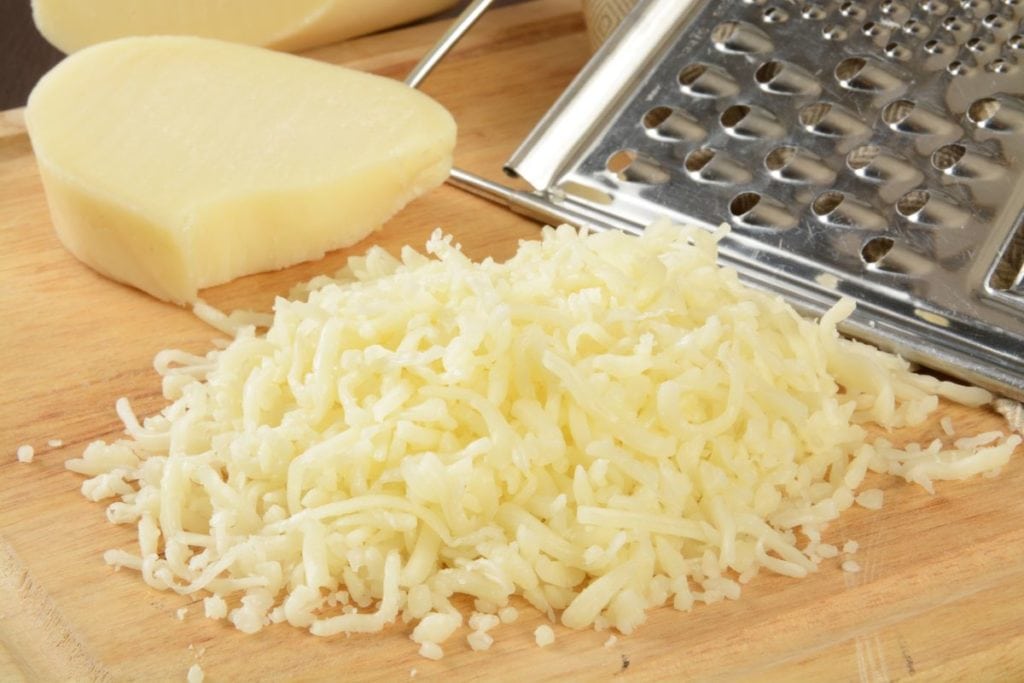 Grated mozzarella cheese in a wooden bowl