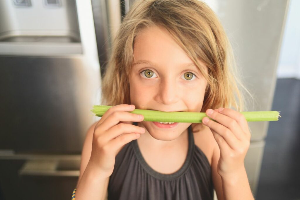 little girl enjoy eating Celery